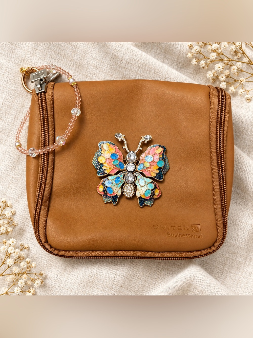 United BusinessFirst Tan Travel Pouch with Custom Butterfly Brooch